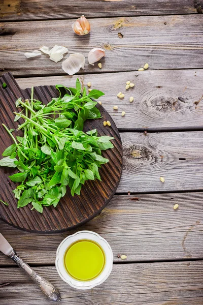 Albahaca fresca sobre tabla de cortar de madera y aceite de oliva sobre la mesa . —  Fotos de Stock