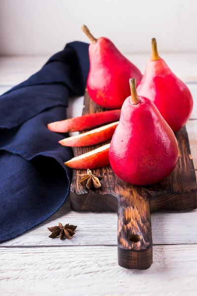 Rode peren op witte houten achtergrond. — Stockfoto