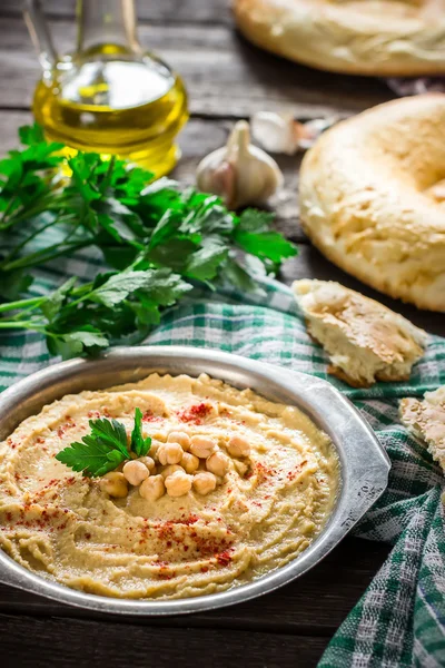 Hummus en cuenco de metal sobre mesa de madera . — Foto de Stock