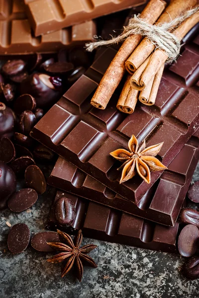 Delicious chocolates and spices on a dark background. — Stock Photo, Image