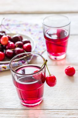 Beyaz ahşap zemin üzerine vişne limonata.