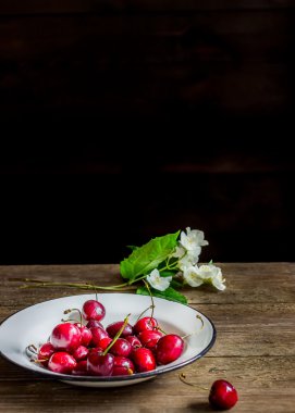 Tatlı kiraz ahşap masa üzerinde beyaz kase. 