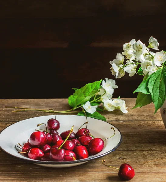 Cereja doce em tigela branca na mesa de madeira . — Fotografia de Stock
