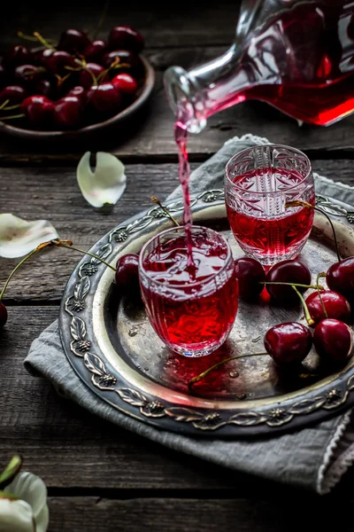 Cherry zelfgemaakte drank stroomt in een vintage glas. — Stockfoto