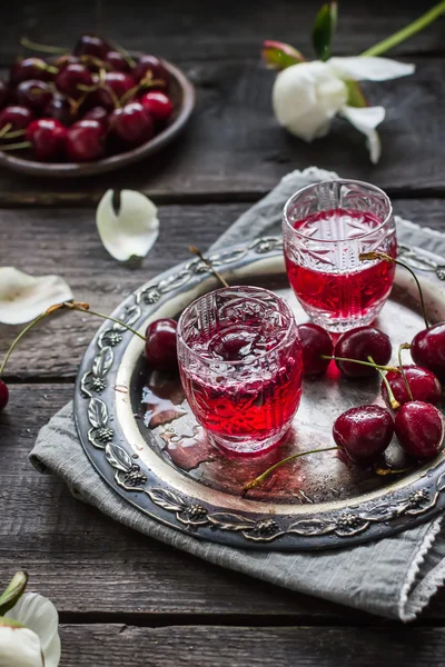 Licor caseiro de cereja em copos vintage em bandeja de metal e cerejas . — Fotografia de Stock