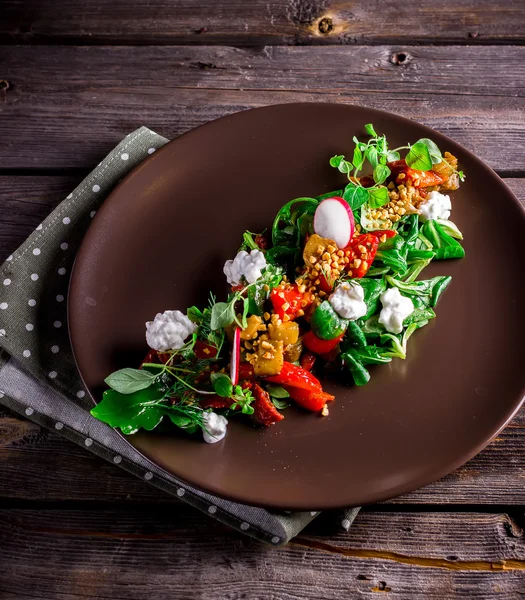 Ensalada con queso de cabra, verduras y pimienta a la parrilla en plato marrón . — Foto de Stock