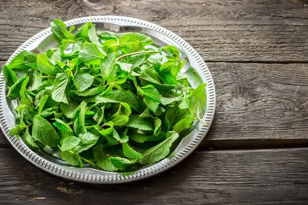 Silver tray with mint leaves on a old wooden table. — Stock Photo, Image