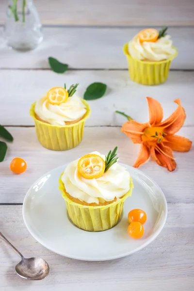 Cupcakes with cream cheese on white wooden table. — Stock Photo, Image