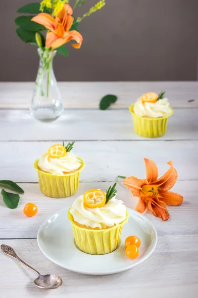 Cupcakes with cream cheese on white wooden table. — Stock Photo, Image