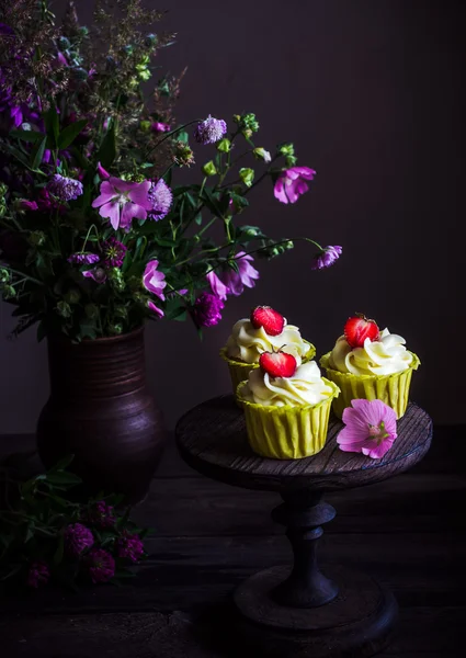 Cupcakes com morango em mesa de madeira escura . — Fotografia de Stock