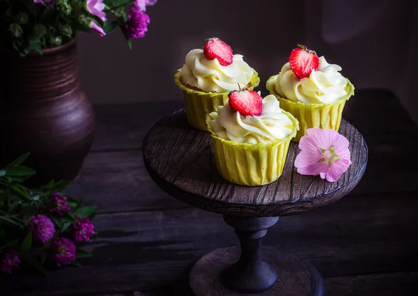 Cupcakes with strawberry on dark wooden table. — Stock Photo, Image