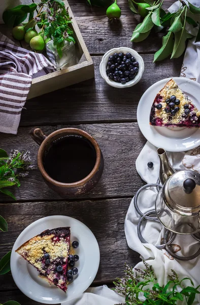 Cup of tea and slice of blueberry pie on dark wooden background. — Stock Photo, Image