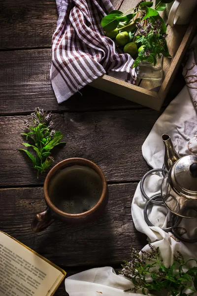 Чашка чая, чайник и книга на темном деревянном фоне — стоковое фото