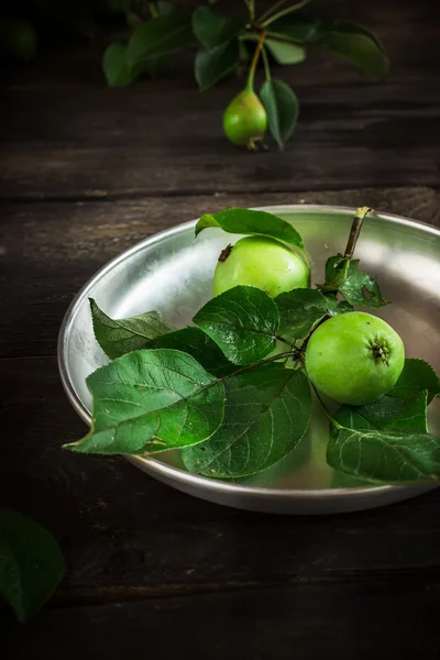 Čerstvá zelená jablka s listy na pozadí tmavě rusric. — Stock fotografie