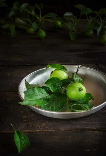 Verse groene appels met bladeren op donkere rusric achtergrond. — Stockfoto