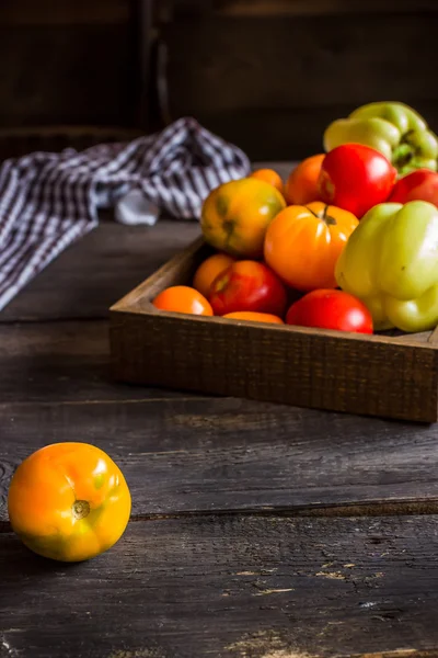 Rode en gele tomaten in houten kist. — Stockfoto