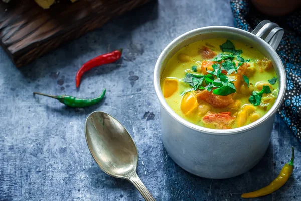 Sopa en taza con garbanzo y especias sobre fondo azul . — Foto de Stock