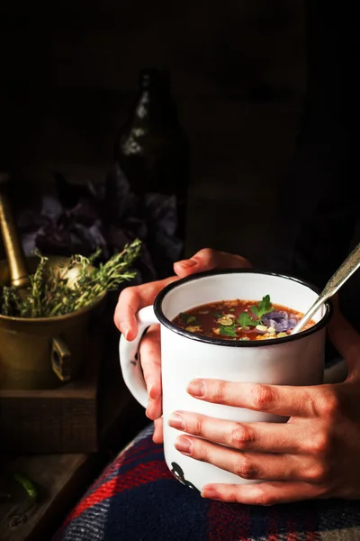 Taza con sopa en manos femeninas . — Foto de Stock