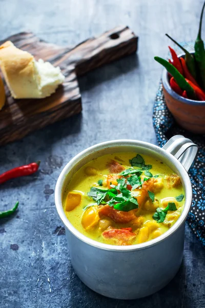 Sopa en taza con garbanzo y especias sobre fondo azul . — Foto de Stock