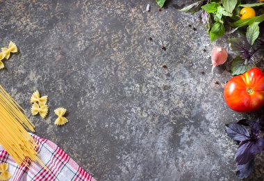 Farklı domates, fesleğen, spagetti, zeytinyağı, sarımsak ve tahta kaşık ile İtalyan yemeği arka plan. 