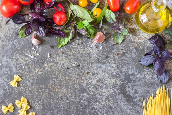 Fundo de comida italiana, com diferentes tomates, manjericão, azeite, alho e colher de madeira . — Fotografia de Stock