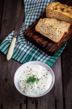 Rustik arka planda çok tahıllı ekmek, dereotu ve baharatlı yoğurt. 