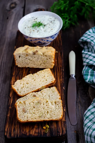 Pão multigrãos, endro e iogurte temperado sobre fundo rústico . — Fotografia de Stock