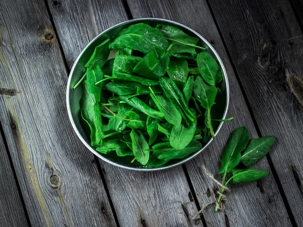 Garden sorrel in a bowl on wooden table. Style rustic. . — Stock Photo, Image