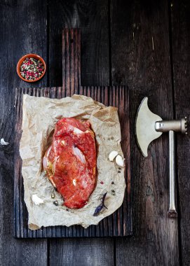 Sarımsak ve ahşap masa üzerinde balta ile çiğ et. 