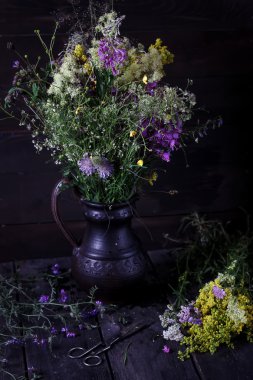 Çiçekler koyu ahşap masa üzerinde bir medow ile sürahi. Rustik tarzı, 