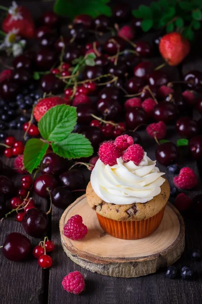 カップケーキと暗い背景の木の果実の多く. — ストック写真