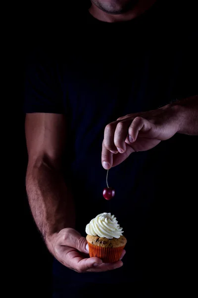Cupcake ve kiraz içinde mans eller.