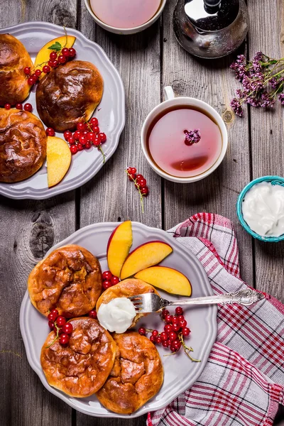 Cheesecakes meyve ve çilek ve iki bardak çay ahşap tablo.