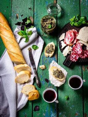 Et ve peynir, baquette, pesto ve şarap.
