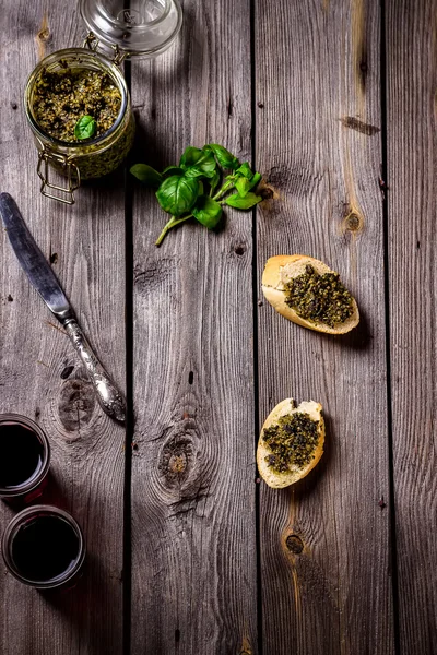Pesto, vino e due fette di baquette in tavola . — Foto Stock