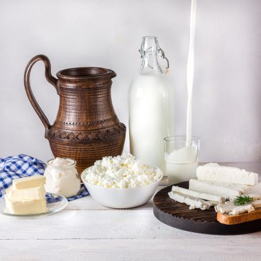 Beyaz ahşap masa üstünde süt ürünleri. 