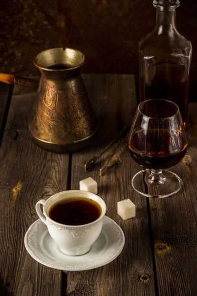 Café y coñac sobre mesa de madera . —  Fotos de Stock