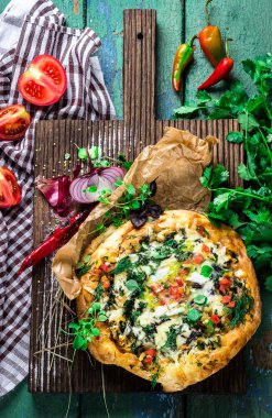 Ev yapımı pizza kesme tahtası üzerinde otlar ile dekore edilmiştir..