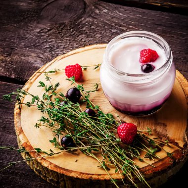 Çilek ve ahşap arka plan üzerinde otlar ile yoğurt. 