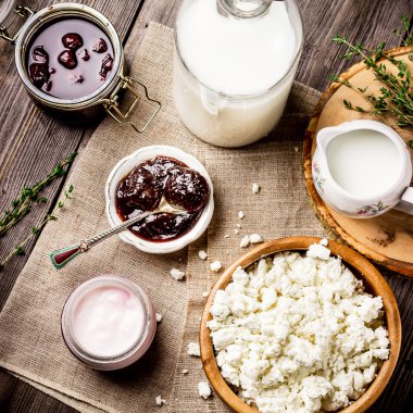 Süt ürünleri: süt, yoğurt ve peynir koyu ahşap tablo.