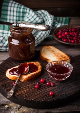 Tost, reçel ve karanlık kesme tahtası üzerinde yabanmersini. 