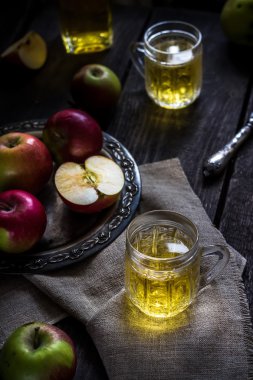 Elma suyu ve elma eski metal tepsi. Koyu ahşap masa. 