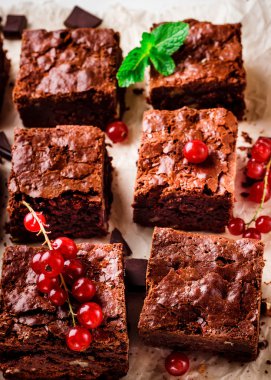  Fındıklı Brownie adet çilek ile dekore edilmiş ve beyaz kağıt üzerine nane yaprakları.