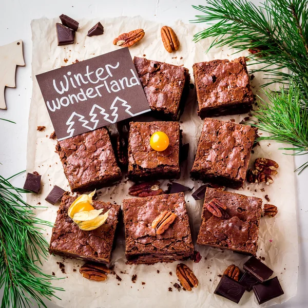 Brownie pezzi con noci e cartolina di Natale sulla carta bianca . — Foto Stock