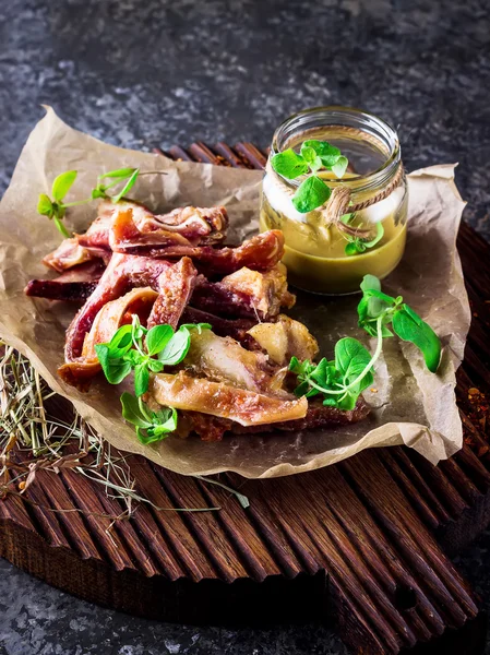 Orejas de cerdo ahumadas con salsa de mostaza en tabla de picar . — Foto de Stock