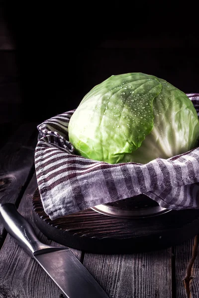 Kohl und Messer auf dunklem Holzgrund. — Stockfoto