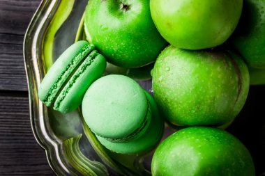 Macaroons ve vintage metal tepsi üzerinde yeşil elma. 