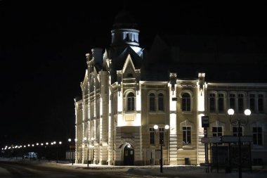 Bir binanın önündeki saat kulesi.