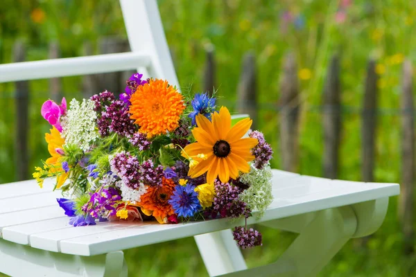 Πολύχρωμα Άγρια Καλοκαιρινά Λουλούδια Μια Καρέκλα Κήπου — Φωτογραφία Αρχείου