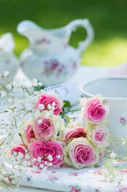 Bahçe masasında pembe güller.